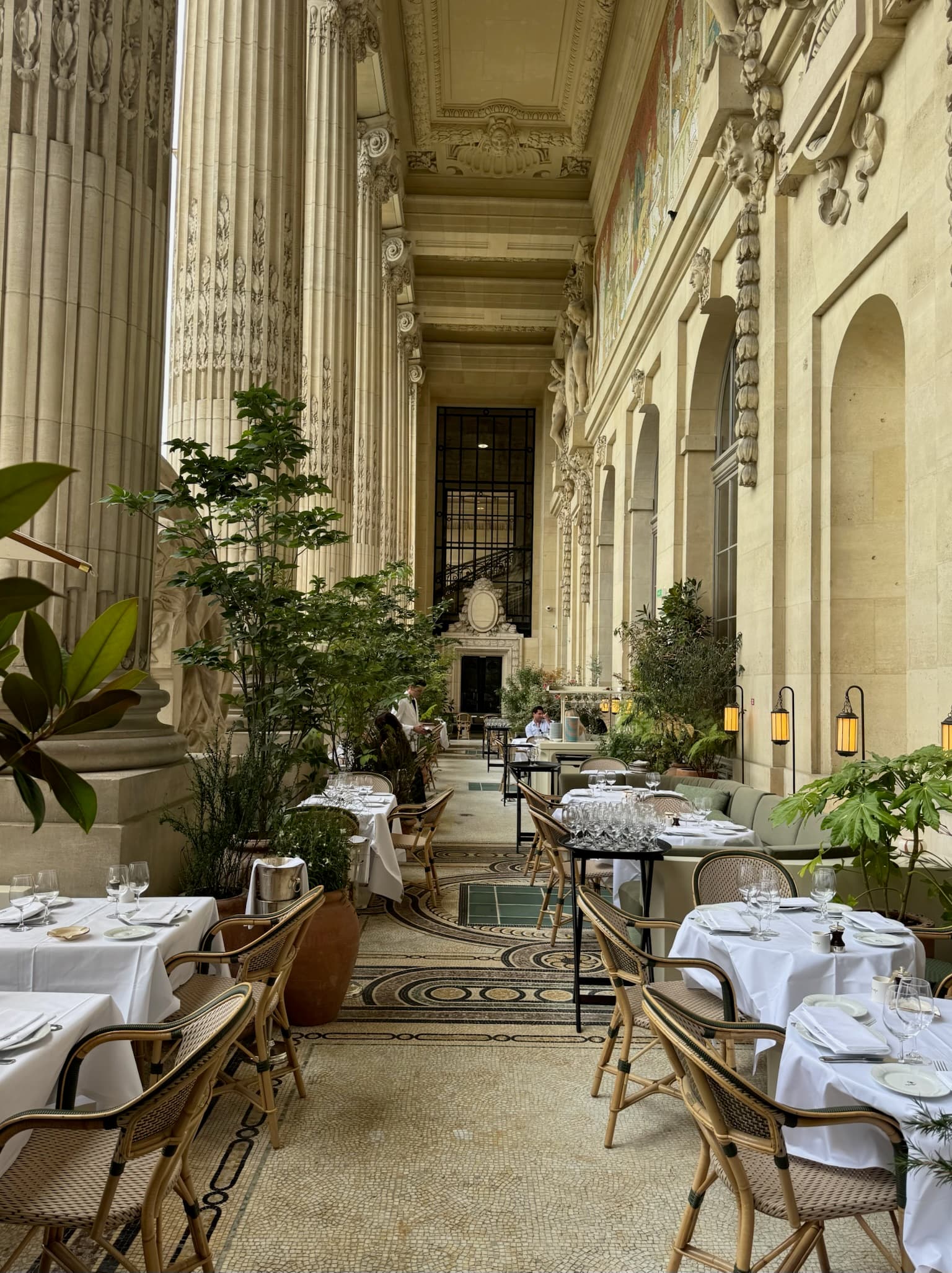 Elegant restaurant dining room with stone columns and formally set tables